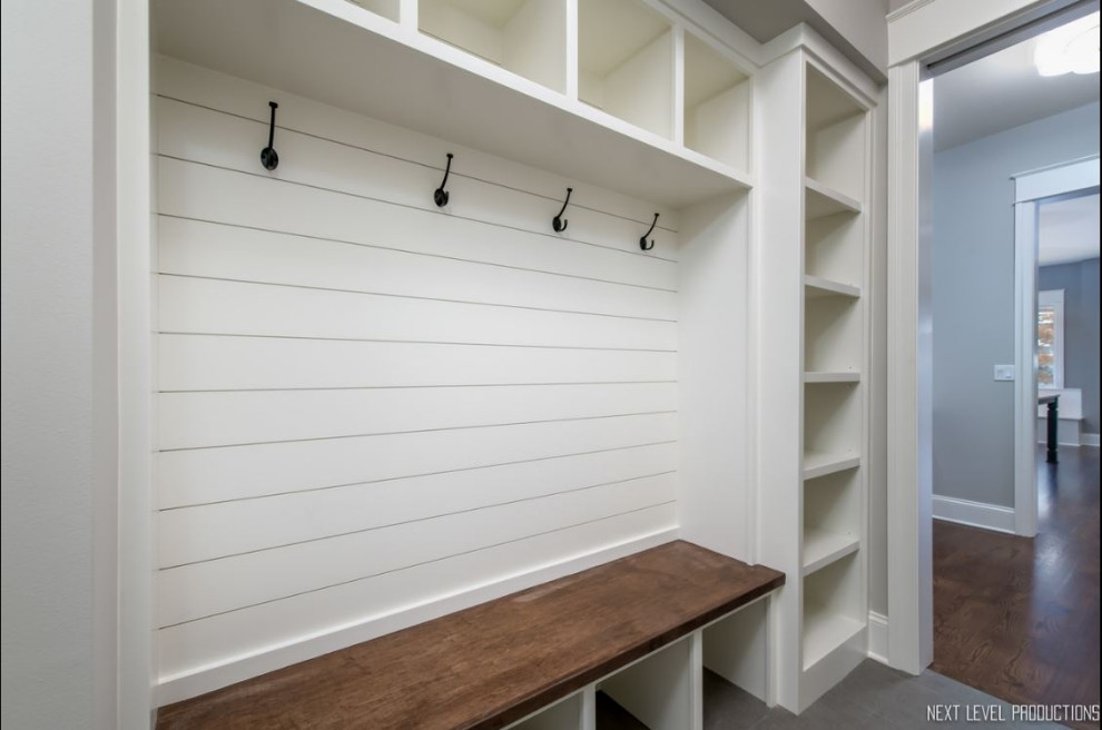 Mid-sized country gender-neutral storage and wardrobe in Chicago with open cabinets, white cabinets, ceramic floors and grey floor.