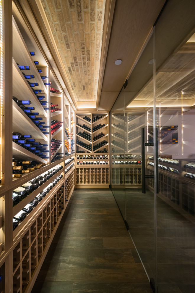 Design ideas for a large transitional wine cellar in New York with porcelain floors, display racks and brown floor.