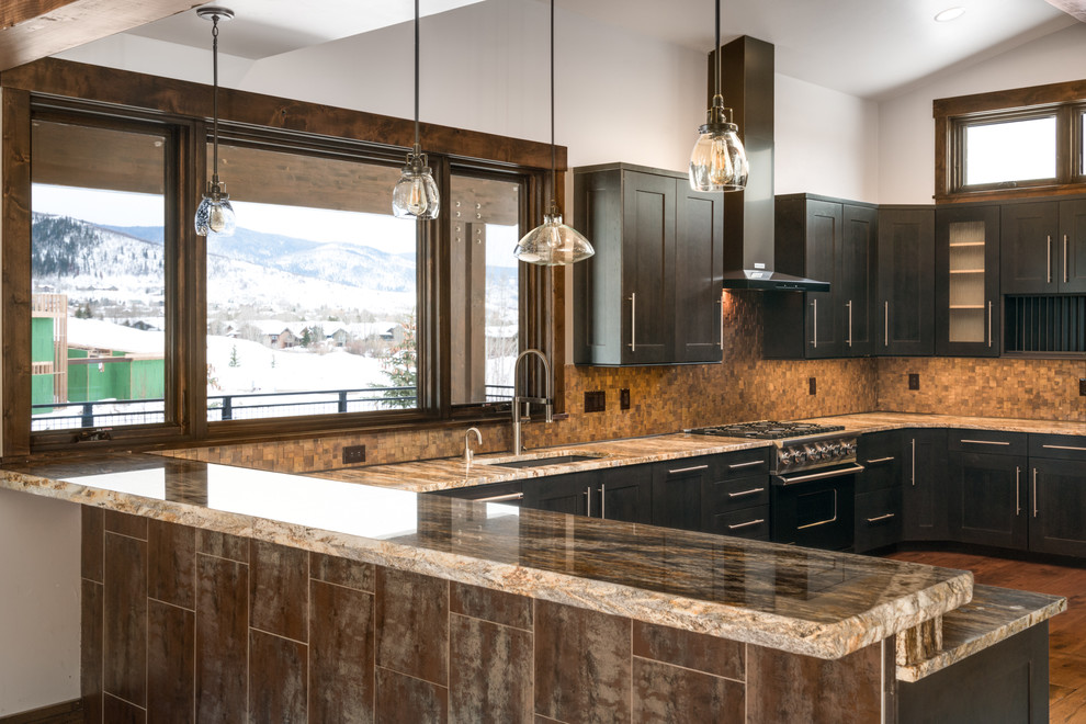 Design ideas for a contemporary u-shaped eat-in kitchen in Denver with an undermount sink, recessed-panel cabinets, black cabinets, granite benchtops, metallic splashback, metal splashback, black appliances, medium hardwood floors, a peninsula, brown floor and multi-coloured benchtop.