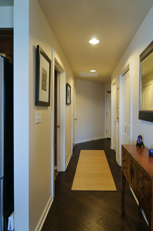 This is an example of a small asian hallway in Seattle with beige walls and dark hardwood floors.