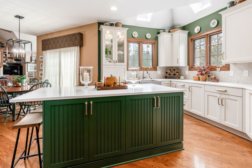 Example of a transitional u-shaped medium tone wood floor and brown floor eat-in kitchen design in Columbus with a farmhouse sink, recessed-panel cabinets, white cabinets, quartzite countertops, beige backsplash, mosaic tile backsplash, stainless steel appliances, an island and white countertops