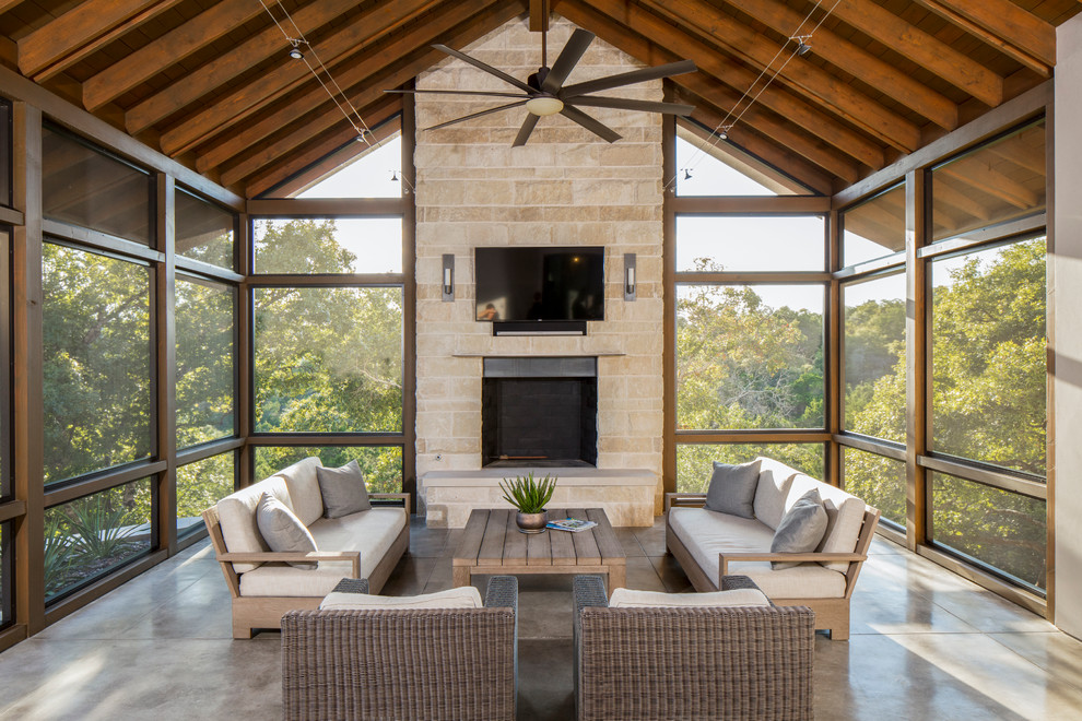 Design ideas for a transitional backyard screened-in verandah in Austin with a roof extension.