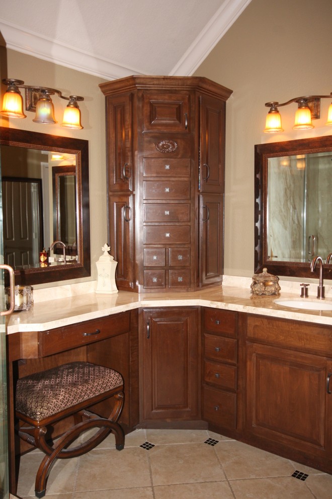 Inspiration for a large traditional master bathroom in Houston with raised-panel cabinets, dark wood cabinets, an alcove shower, beige walls, travertine floors, an undermount sink, marble benchtops, beige floor, a hinged shower door and beige benchtops.