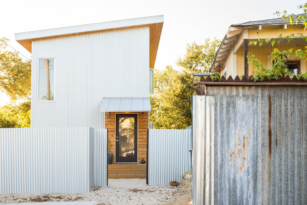 This is an example of a mid-sized industrial two-storey grey house exterior in Austin with metal siding, a shed roof and a metal roof.