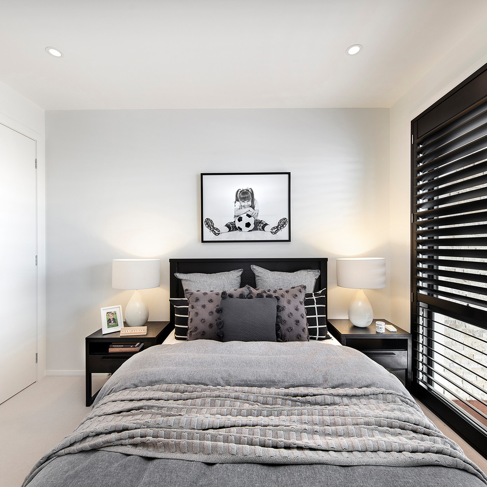 Design ideas for a mid-sized contemporary guest bedroom in Wollongong with white walls, carpet and beige floor.