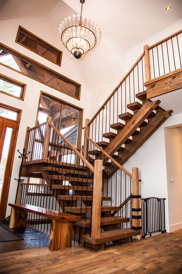 This is an example of an arts and crafts wood l-shaped staircase in Montreal with open risers and metal railing.