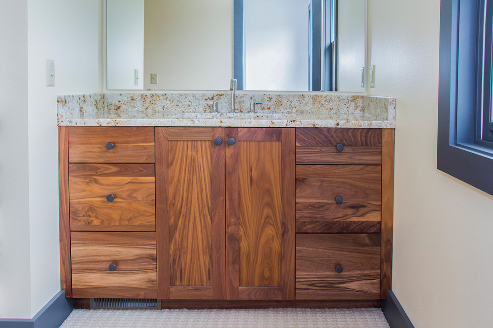 This is an example of a small contemporary 3/4 bathroom in Milwaukee with an undermount sink, flat-panel cabinets, medium wood cabinets, granite benchtops and white walls.