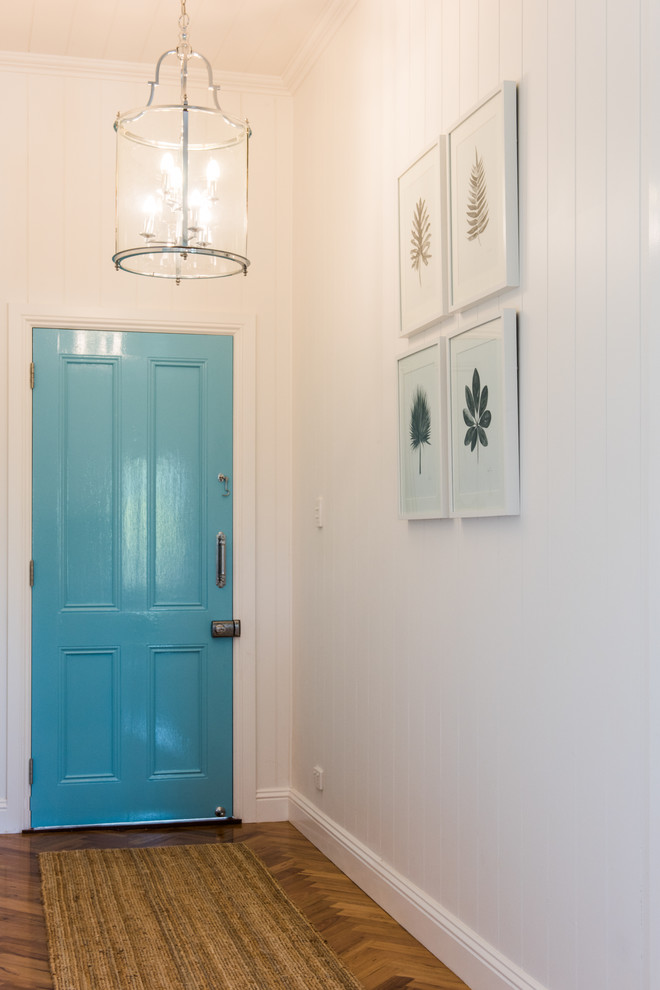 Photo of a small traditional front door in Brisbane with white walls, medium hardwood floors, a single front door, a blue front door and brown floor.