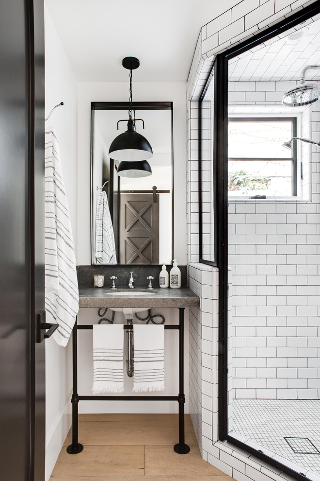 Inspiration for a beach style bathroom in Los Angeles with a corner shower, white tile, subway tile, white walls, medium hardwood floors, an undermount sink, brown floor, a hinged shower door and grey benchtops.