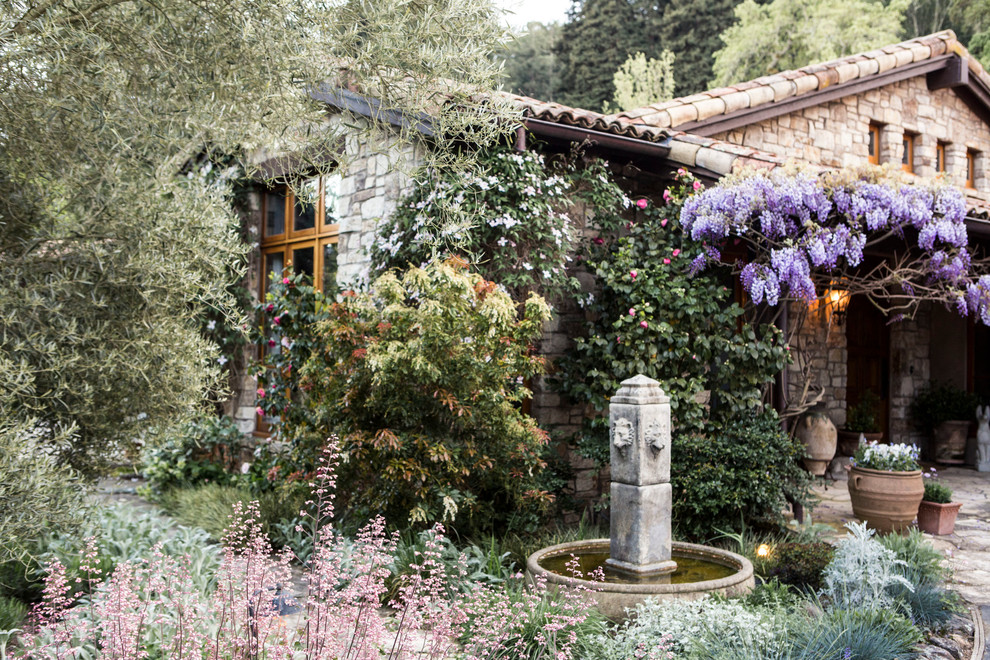 This is an example of a large rustic drought-tolerant and partial sun backyard gravel water fountain landscape.