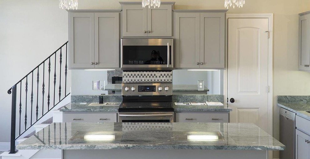 Inspiration for a mid-sized transitional l-shaped light wood floor and gray floor eat-in kitchen remodel in Miami with shaker cabinets, gray cabinets, granite countertops, mirror backsplash, stainless steel appliances, an island, an undermount sink and metallic backsplash