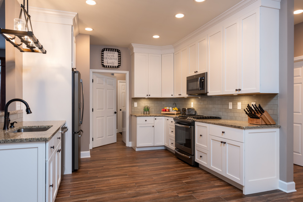 Inspiration for a mid-sized transitional galley porcelain tile and brown floor open concept kitchen remodel with an undermount sink, shaker cabinets, white cabinets, granite countertops, green backsplash, subway tile backsplash, stainless steel appliances, an island and multicolored countertops