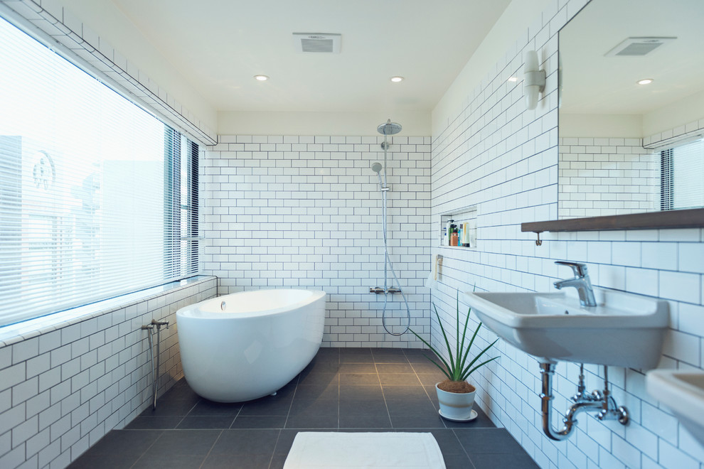 Design ideas for a contemporary master bathroom in Tokyo with a freestanding tub, a curbless shower, subway tile, white walls, a wall-mount sink, grey floor and an open shower.