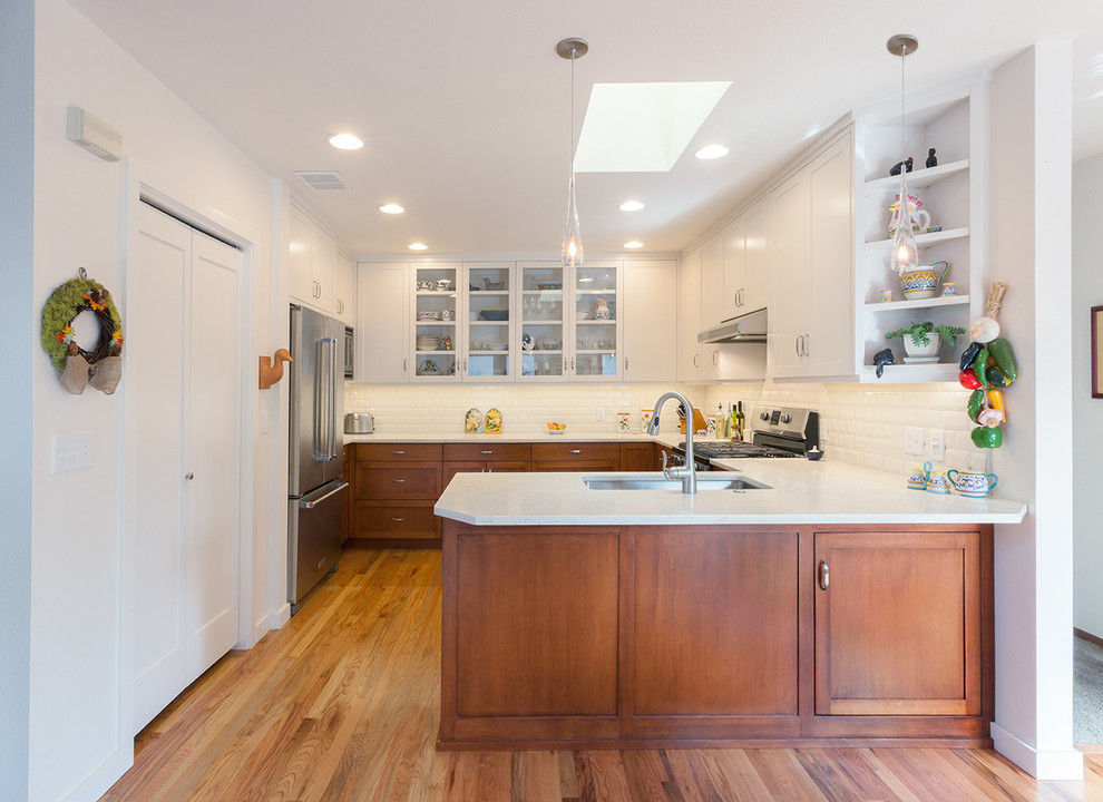Transitional light wood floor kitchen photo with a double-bowl sink, shaker cabinets, quartz countertops, white backsplash, subway tile backsplash and stainless steel appliances