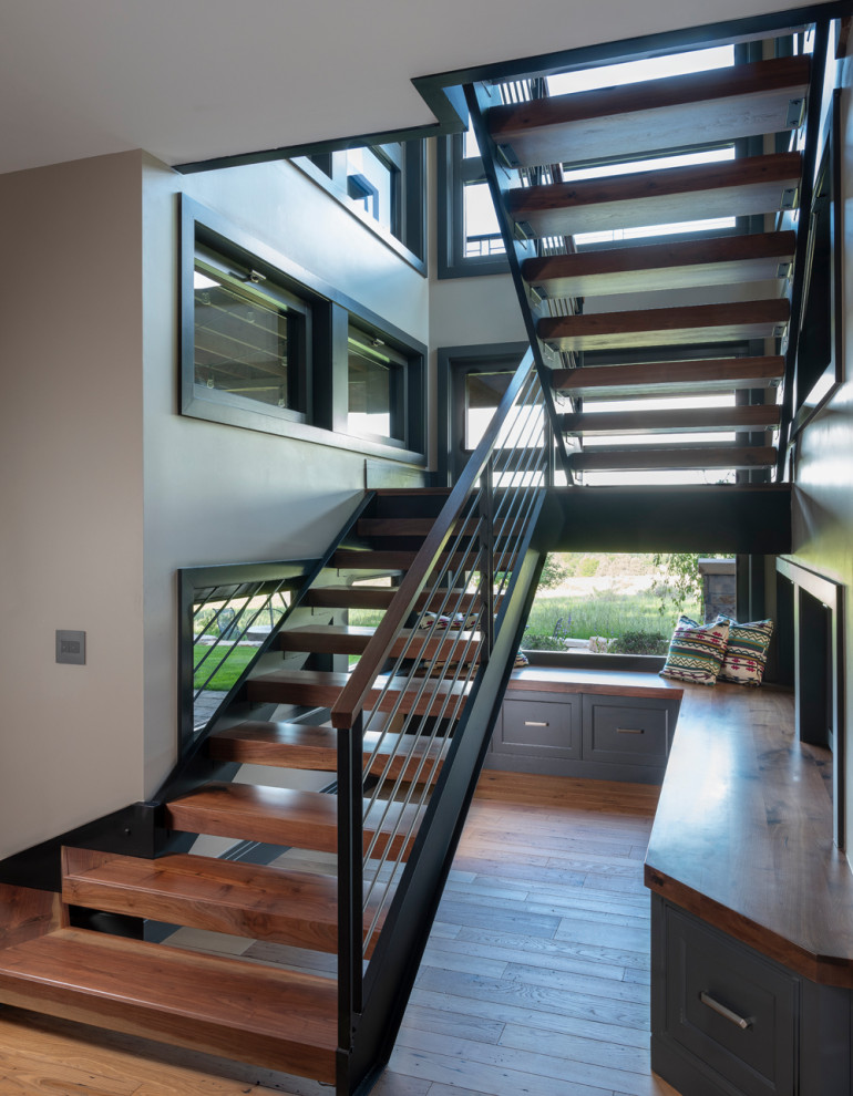 Photo of a mid-sized arts and crafts wood floating staircase in Denver with open risers and metal railing.