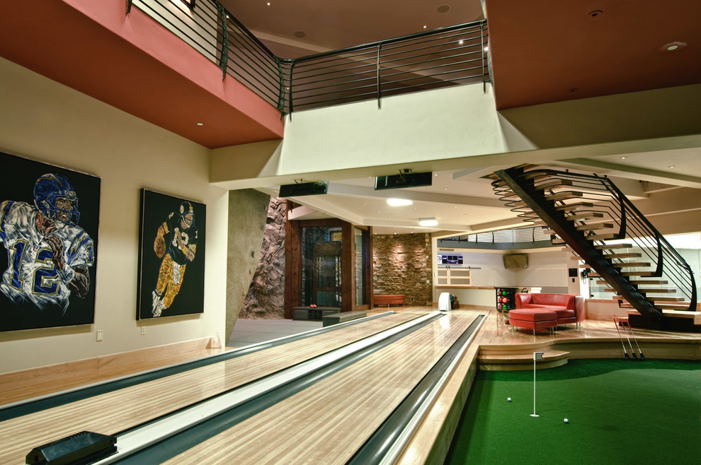 Photo of a large contemporary basement in Salt Lake City with a game room, beige walls and light hardwood floors.