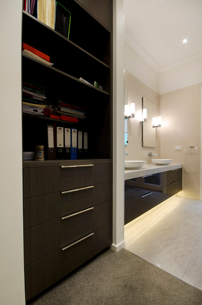 Inspiration for a large contemporary gender-neutral walk-in wardrobe in Melbourne with flat-panel cabinets, dark wood cabinets, carpet and grey floor.