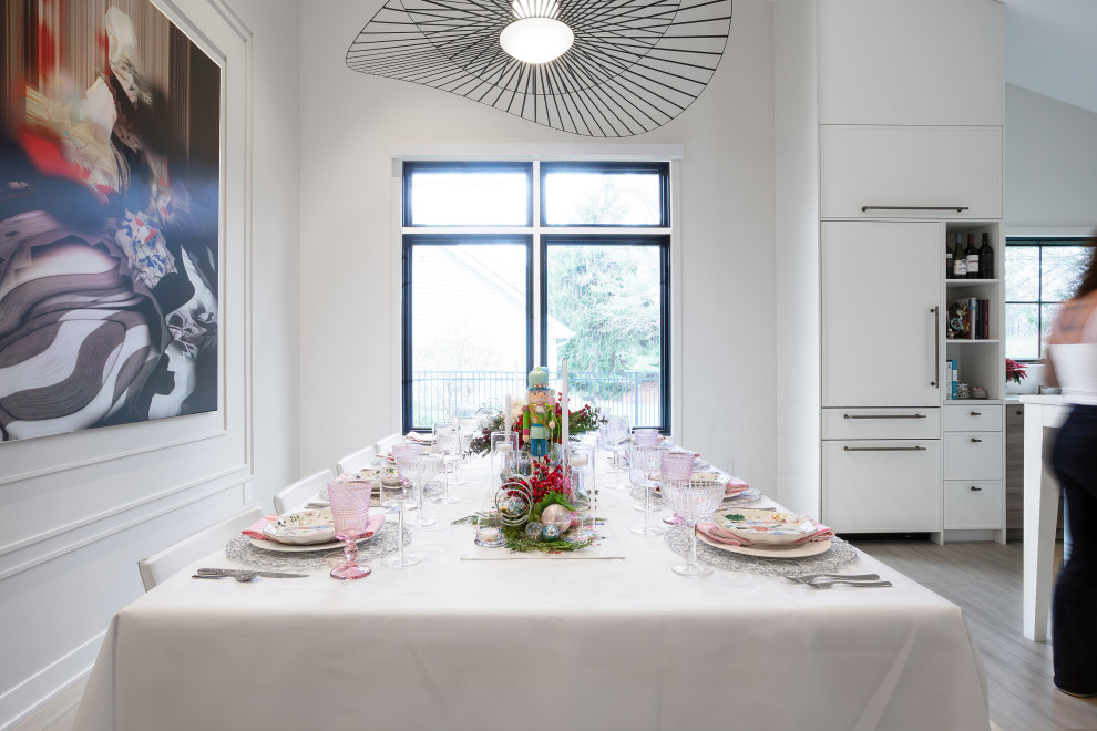 Ispirazione per una sala da pranzo aperta verso la cucina contemporanea con pareti bianche, parquet chiaro e pavimento marrone