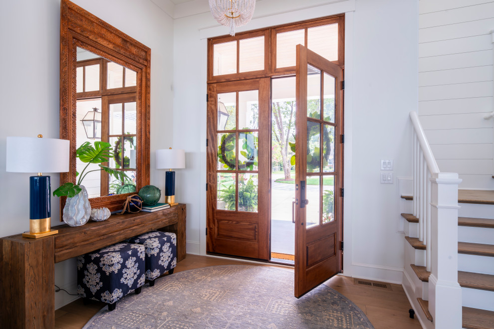 Diseño de puerta principal costera de tamaño medio con paredes blancas, puerta doble, puerta de madera en tonos medios, suelo marrón y machihembrado