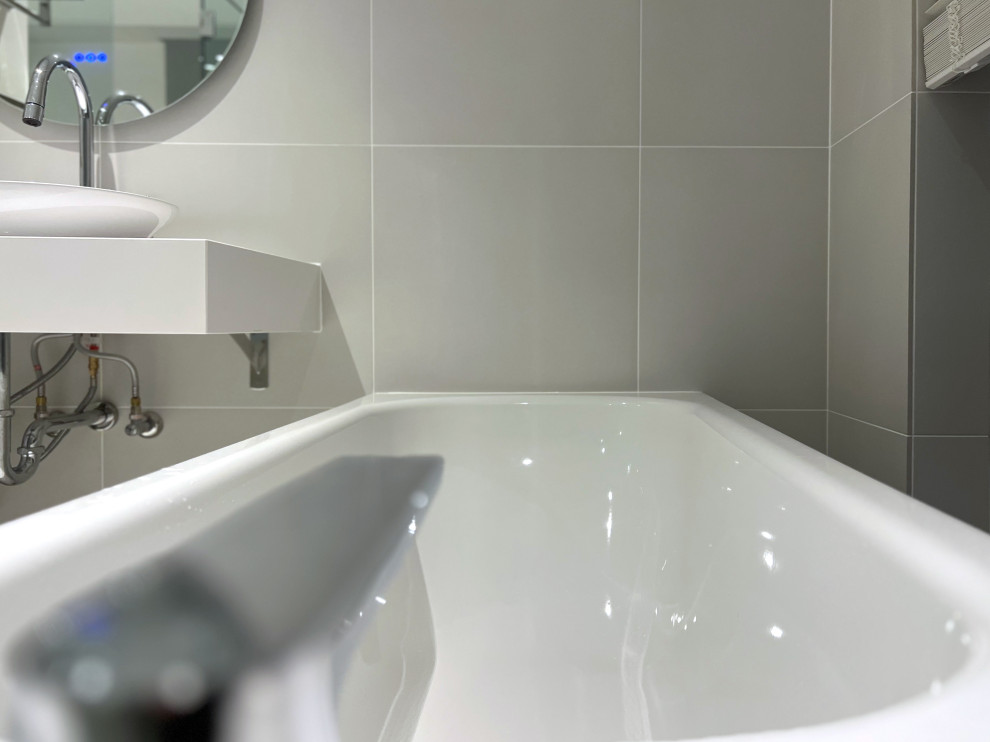 Пример оригинального дизайна: главная ванная комната среднего размера в стиле модернизм с белыми фасадами, накладной ванной, душем над ванной, серой плиткой, полом из керамогранита, раковиной с пьедесталом, серым полом, душем с распашными дверями, белой столешницей, тумбой под одну раковину и подвесной тумбой