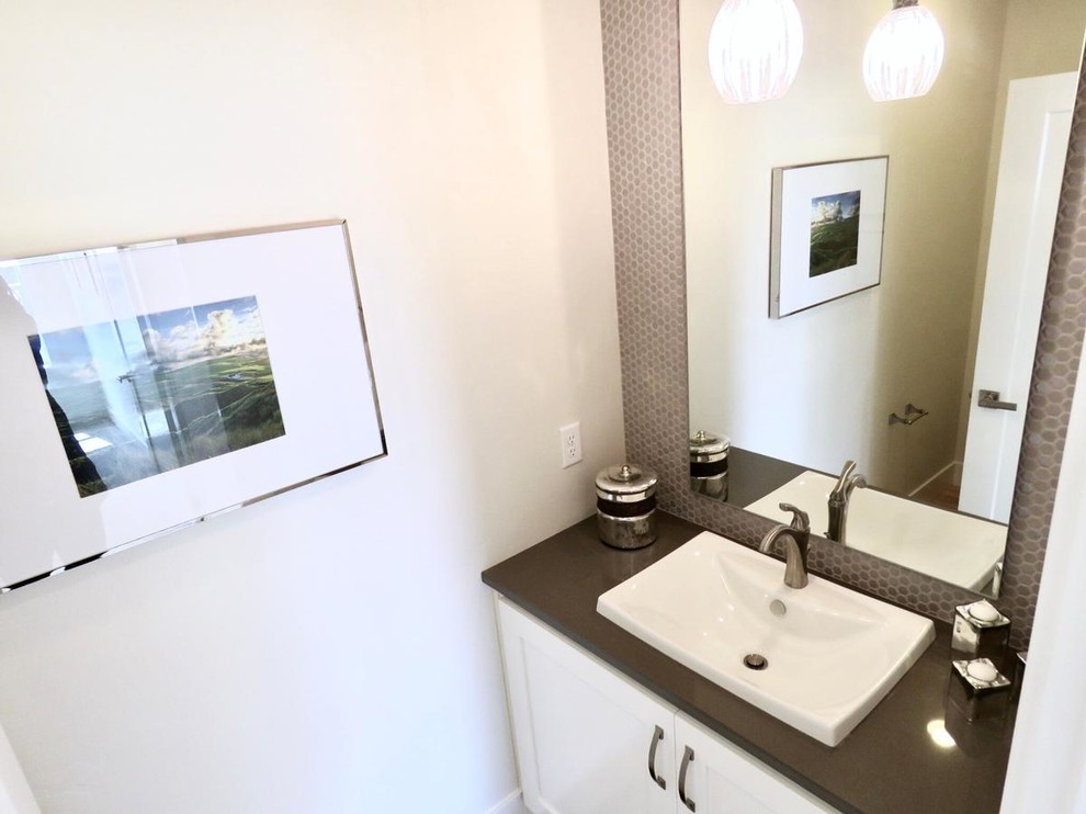 Photo of a mid-sized transitional bathroom in Boise with flat-panel cabinets, white cabinets, beige tile, glass tile, quartzite benchtops, a one-piece toilet, white walls, light hardwood floors and a drop-in sink.