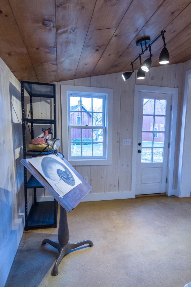 Idéer för ett mellanstort lantligt hemmastudio, med vita väggar, betonggolv och ett fristående skrivbord