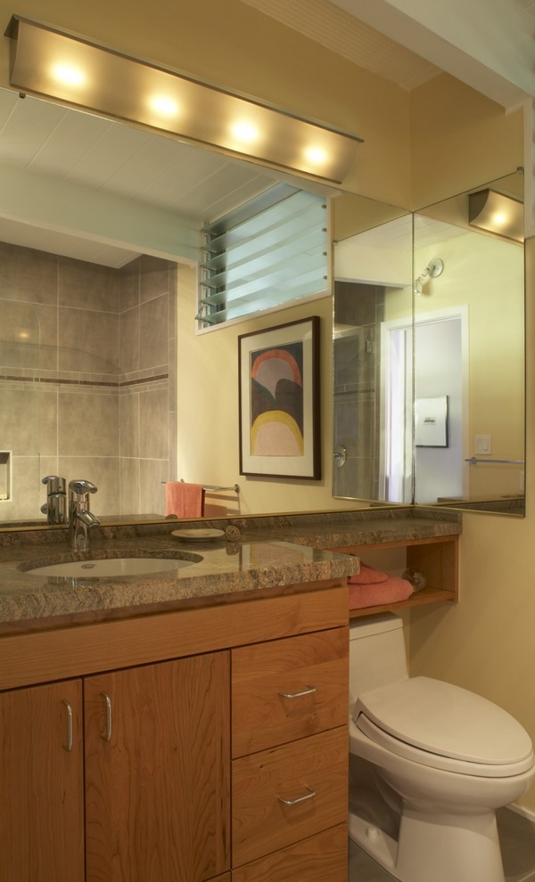 Photo of a mid-sized transitional 3/4 bathroom in San Francisco with flat-panel cabinets, medium wood cabinets, a corner shower, gray tile, beige walls, an undermount sink, granite benchtops, an alcove tub, a two-piece toilet, ceramic tile, porcelain floors, grey floor and a hinged shower door.