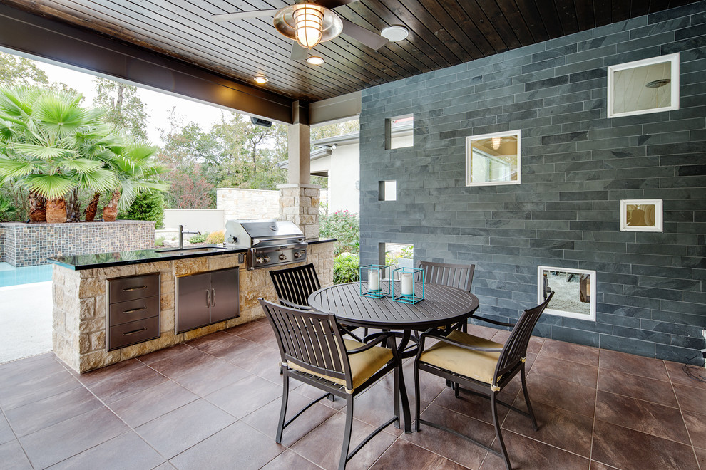 Photo of a mid-sized traditional backyard patio in Houston with a roof extension and tile.