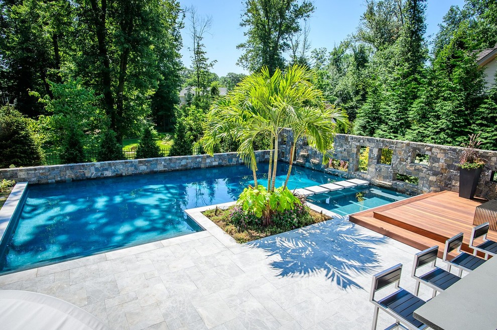 Large backyard stone and custom-shaped pool photo in New York