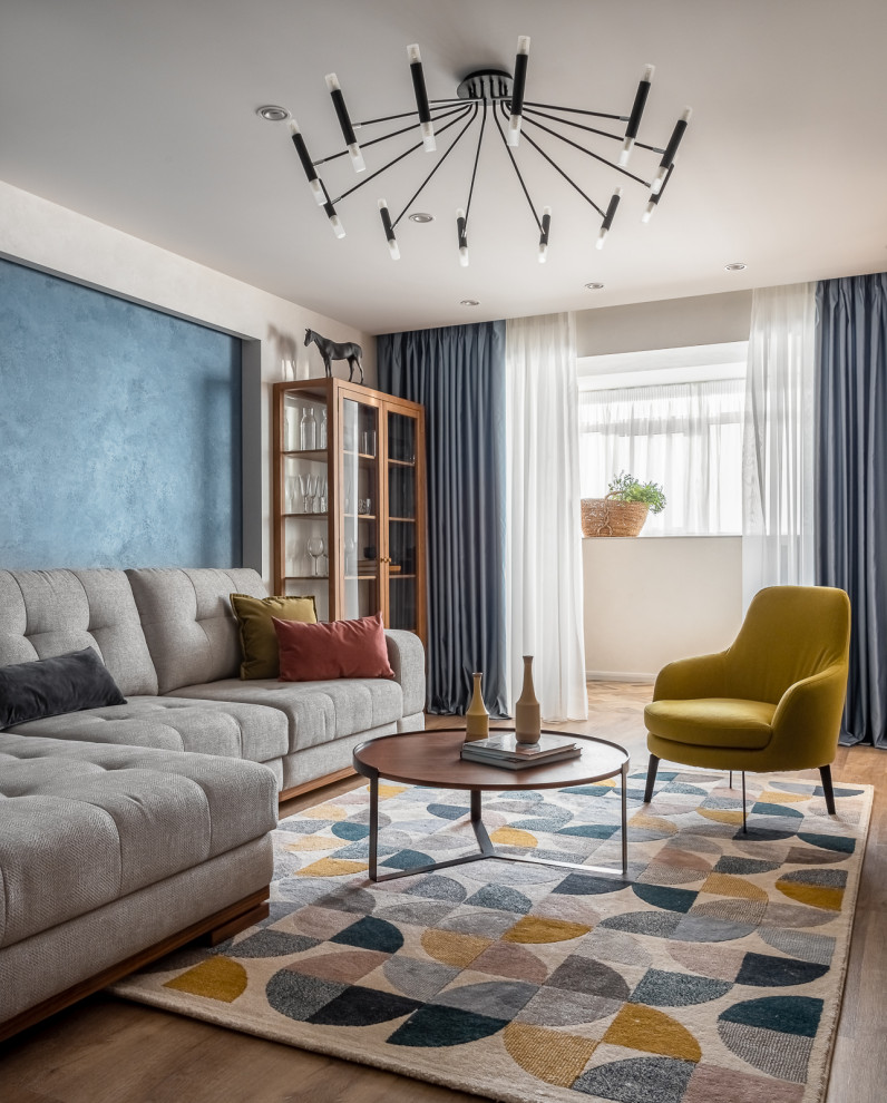 Источник вдохновения для домашнего уюта: открытая, серо-белая гостиная комната среднего размера в современном стиле с синими стенами, светлым паркетным полом, телевизором на стене, коричневым полом и акцентной стеной