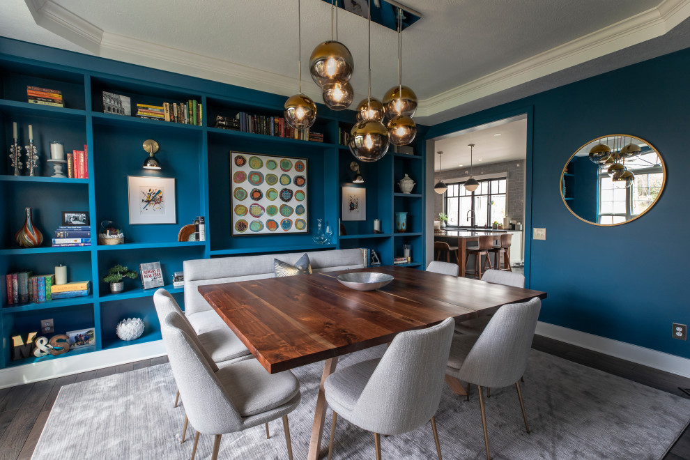 Idée de décoration pour une grande salle à manger tradition avec un manteau de cheminée en carrelage, un mur bleu, parquet foncé, un sol marron et un plafond décaissé.