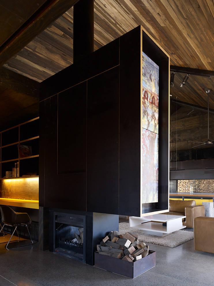 Inspiration for a mid-sized contemporary formal open concept living room in Melbourne with black walls, concrete floors, a wood stove, a metal fireplace surround and a concealed tv.