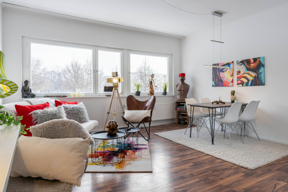 Foto di una piccola sala da pranzo aperta verso il soggiorno minimal con pareti bianche, pavimento in laminato, pavimento marrone e soffitto in carta da parati