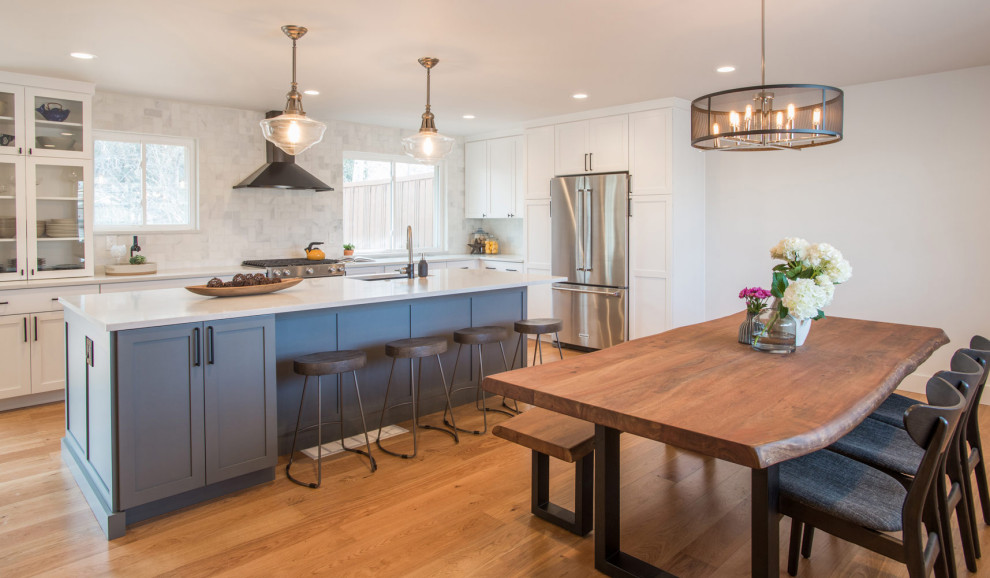 Photo of a medium sized contemporary galley kitchen/diner in Santa Barbara with a submerged sink, glass-front cabinets, beige cabinets, stainless steel appliances, medium hardwood flooring and an island.