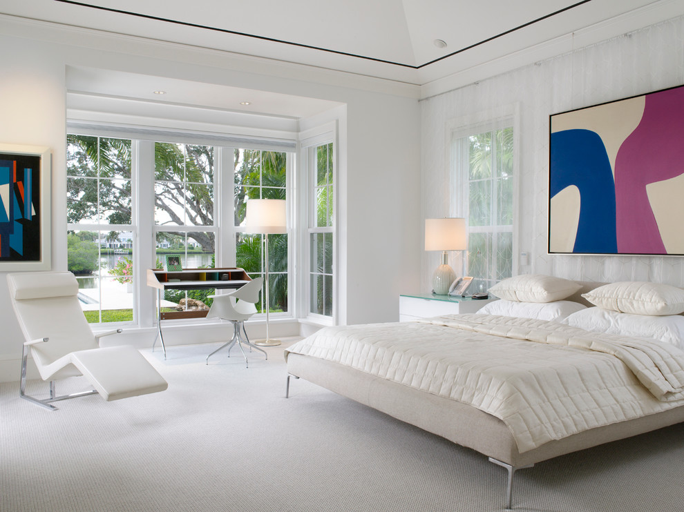This is an example of a large contemporary master bedroom in Miami with white walls and carpet.