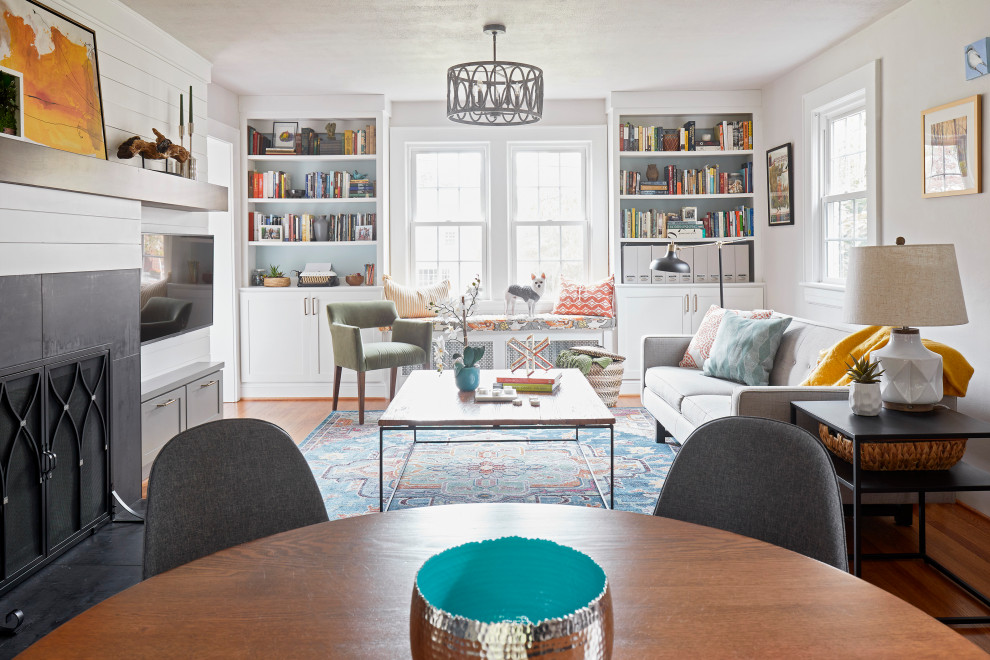 Inspiration for a mid-sized transitional open concept medium tone wood floor and brown floor living room remodel with white walls, a standard fireplace, a tile fireplace and a wall-mounted tv