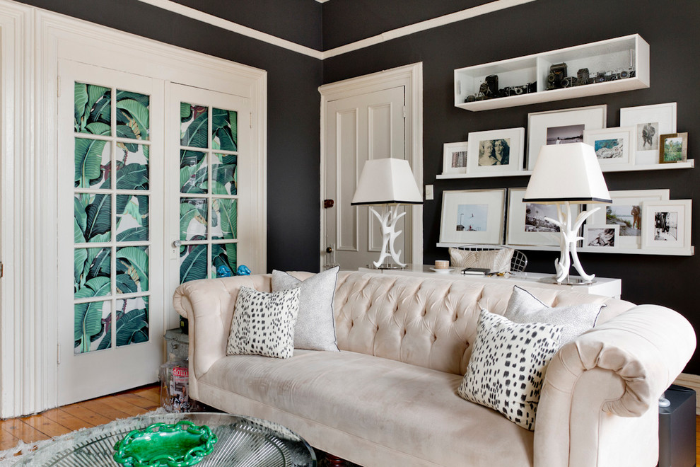 Inspiration for an eclectic formal living room in New York with black walls, medium hardwood floors and no fireplace.