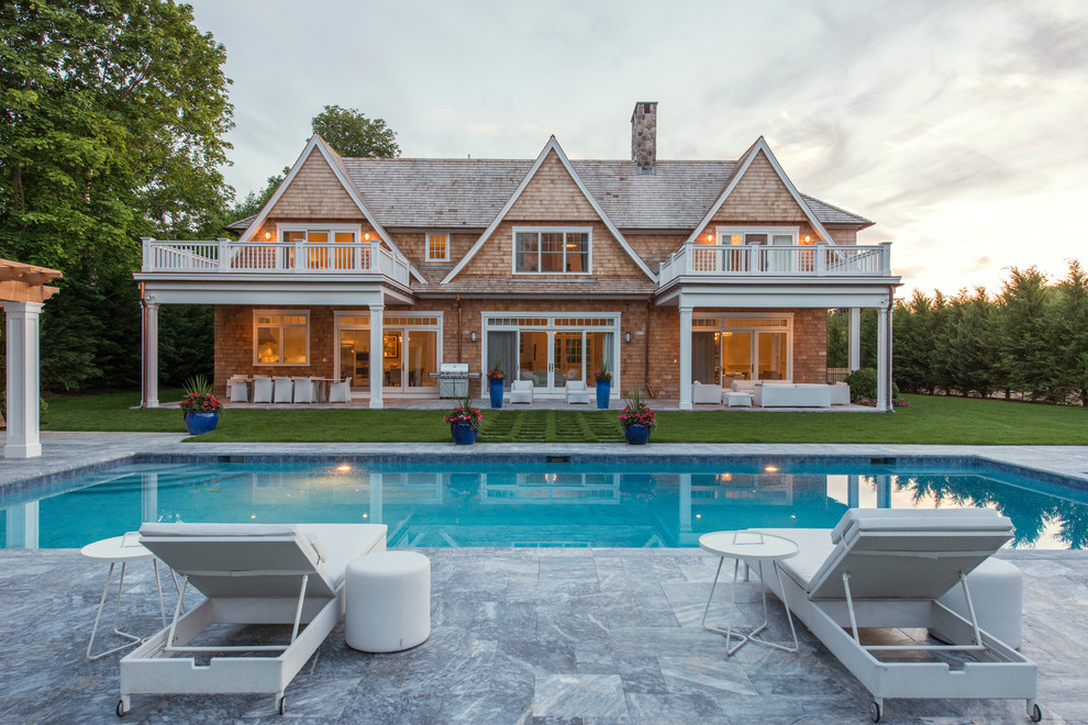 Inspiration for a large traditional backyard rectangular pool in New York with natural stone pavers.