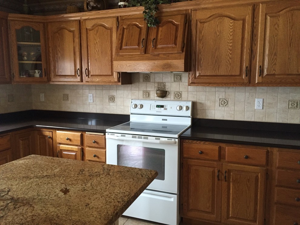Elegant kitchen photo with medium tone wood cabinets, quartz countertops, beige backsplash, white appliances and an island