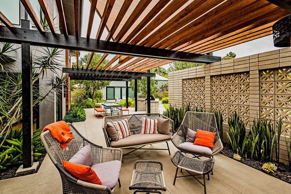 Inspiration for a large midcentury side yard patio in San Diego with concrete slab and a pergola.