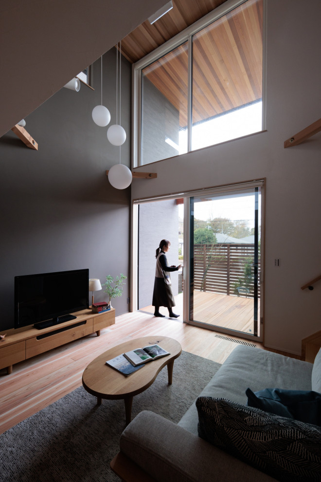 Стильный дизайн: открытая гостиная комната среднего размера в стиле ретро с серыми стенами, паркетным полом среднего тона и акцентной стеной - последний тренд