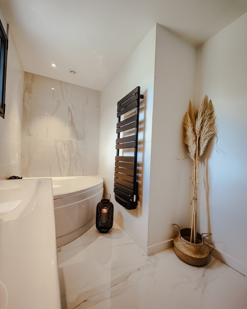 Foto på ett mellanstort funkis vit en-suite badrum, med släta luckor, skåp i ljust trä, ett hörnbadkar, vit kakel, marmorkakel, vita väggar, marmorgolv, ett konsol handfat, kaklad bänkskiva och vitt golv