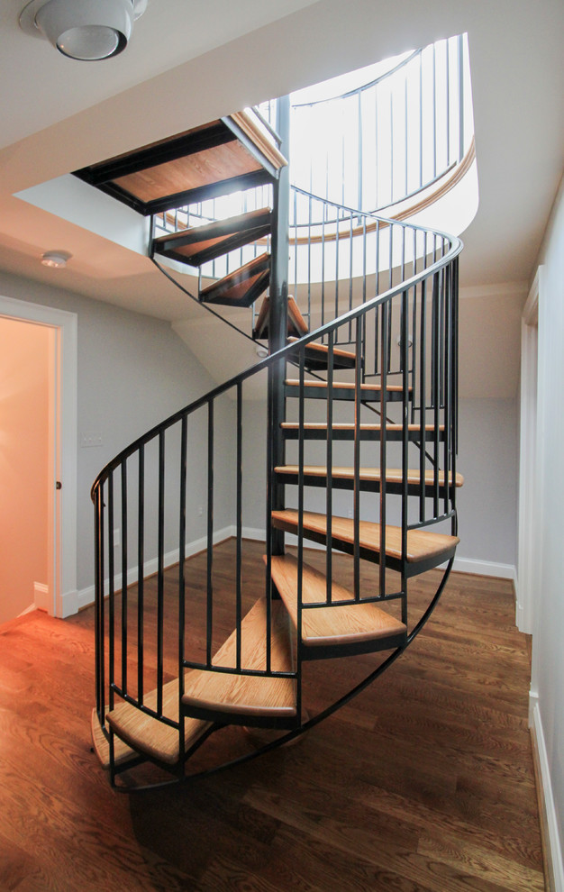 Photo of an expansive traditional wood spiral staircase in DC Metro with wood risers and metal railing.