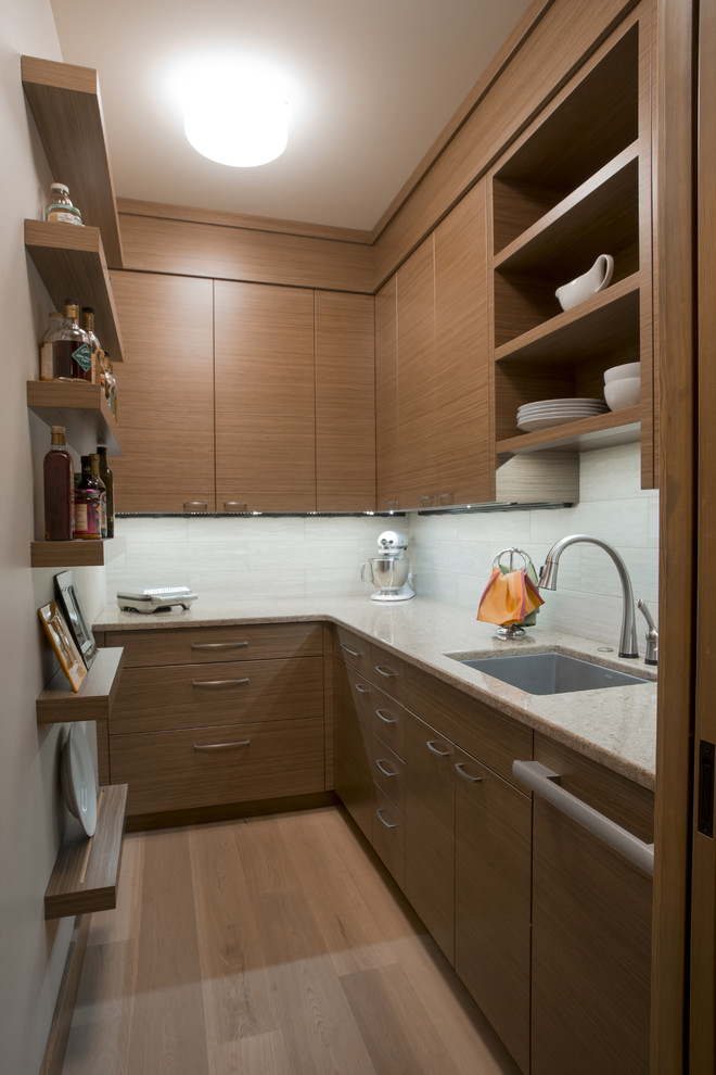 This is an example of a transitional l-shaped kitchen pantry in Seattle with an undermount sink, flat-panel cabinets, medium wood cabinets, quartz benchtops, beige splashback, porcelain splashback, panelled appliances, medium hardwood floors and no island.