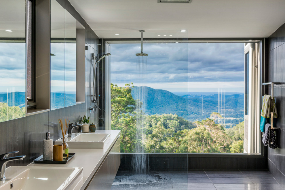 Inspiration for a mid-sized modern master bathroom in Brisbane with flat-panel cabinets, brown cabinets, an open shower, a two-piece toilet, gray tile, porcelain tile, grey walls, porcelain floors, a drop-in sink and engineered quartz benchtops.