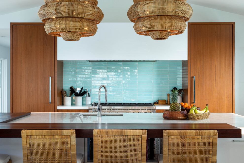 Photo of a contemporary galley kitchen in San Diego with an undermount sink, flat-panel cabinets, medium wood cabinets, blue splashback, stainless steel appliances, with island, white benchtop and vaulted.