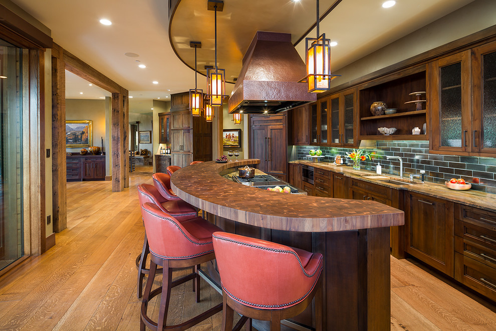 Inspiration for a large rustic galley light wood floor and brown floor eat-in kitchen remodel with an undermount sink, recessed-panel cabinets, dark wood cabinets, brown backsplash, an island, copper countertops, subway tile backsplash and colored appliances