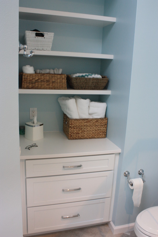 Mid-sized transitional 3/4 beige tile, blue tile and mosaic tile ceramic tile corner shower photo with recessed-panel cabinets, white cabinets, a one-piece toilet, blue walls, an undermount sink and solid surface countertops