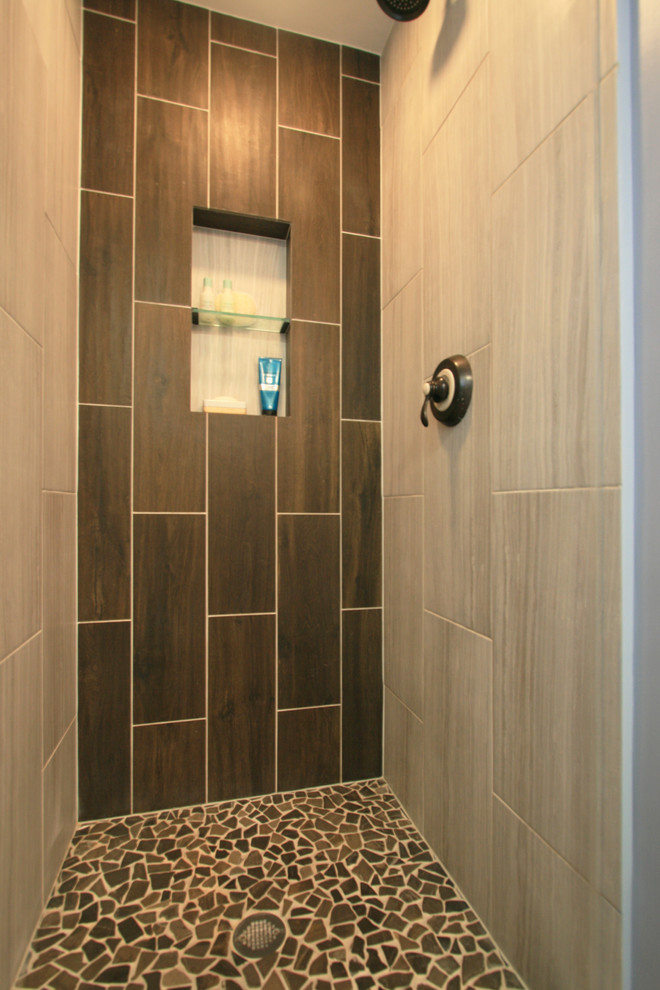 Photo of a mid-sized country bathroom in Chicago with shaker cabinets, dark wood cabinets, an alcove shower, a two-piece toilet, brown tile, ceramic tile, blue walls, ceramic floors, an undermount sink and engineered quartz benchtops.