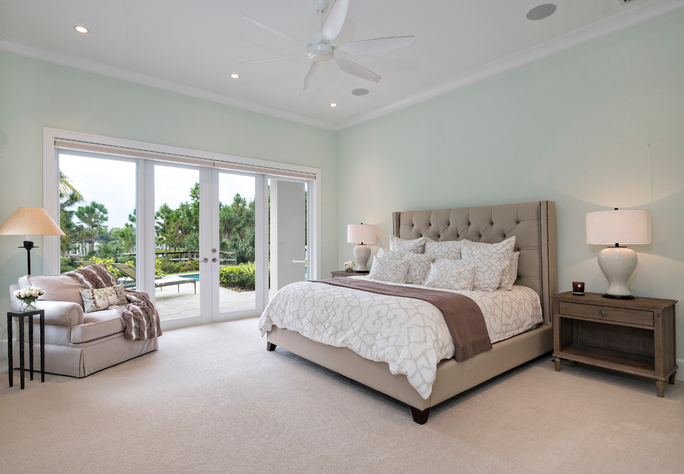 This is an example of a large transitional master bedroom in Miami with green walls, carpet and green floor.